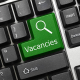 Close up view on conceptual keyboard Vacancies (green key)